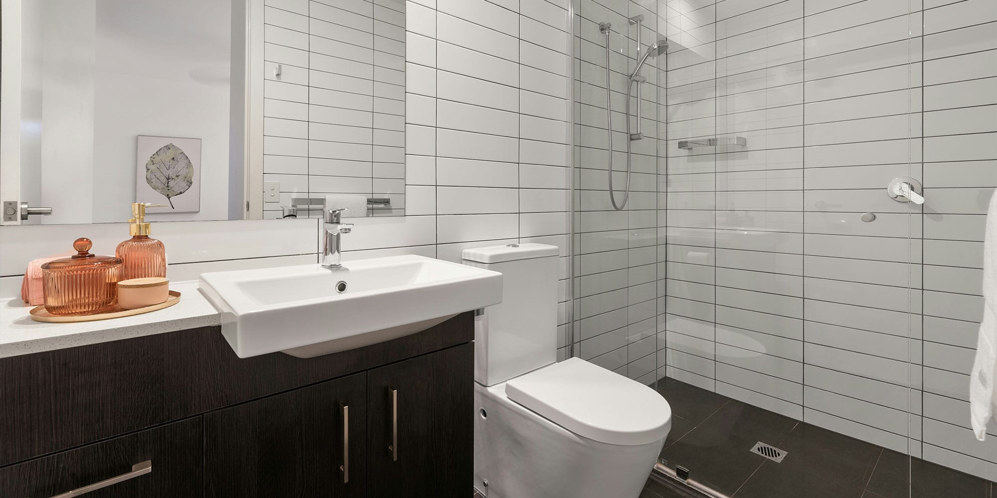 Hohtavan puhdas ja moderni kylpyhuone, jossa kaikki pinnat on puhdistettu moitteettomasti. Tämä on vastaus kysymykseen: 