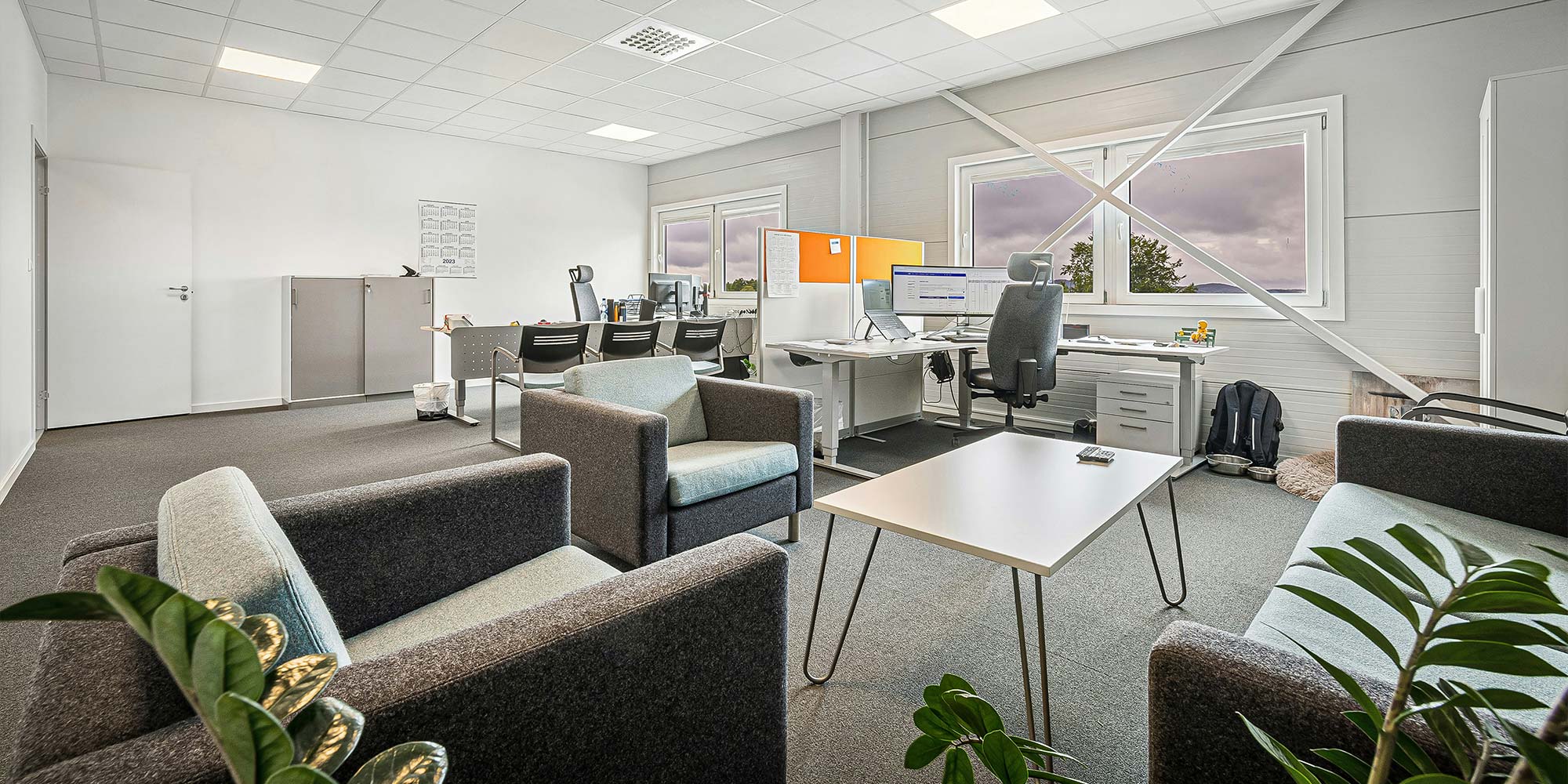 Valoisa ja siisti avokonttori oleskelutiloineen ja työpisteineen – esimerkki Omenasiivouksen yrityssiivouksen laadusta.